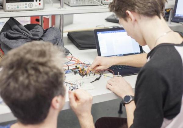 Young male students working together in a computer lab