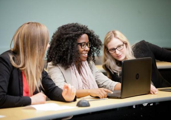 Three female students working together in a computer lab
