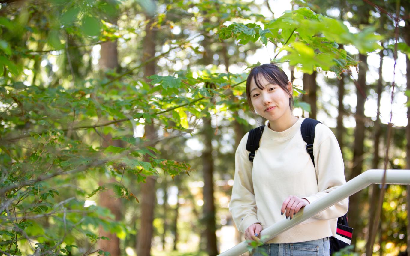 A young woman on a staircase in a forest. 